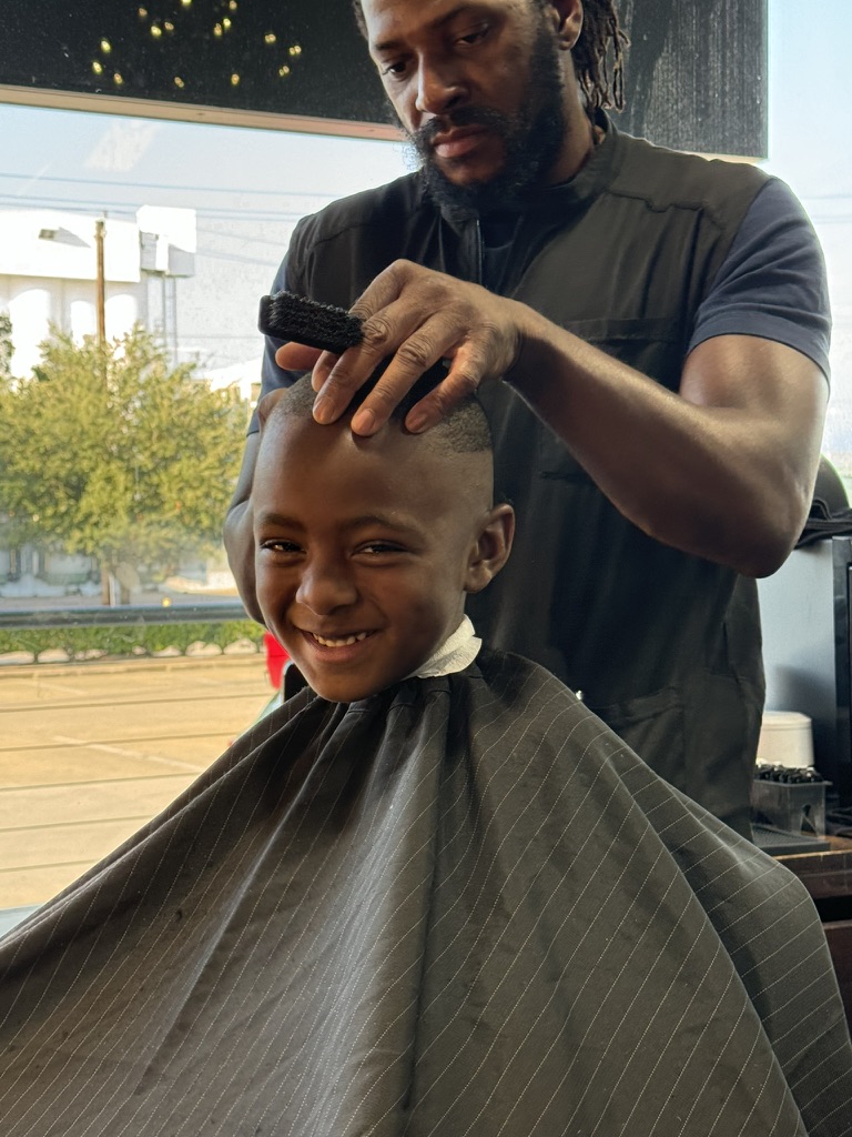 Rolton giving a young client a haircut